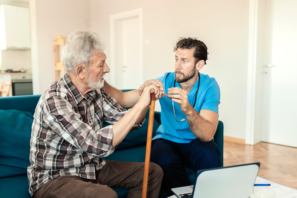 Male Caretaker Talking to Elder Man Patient