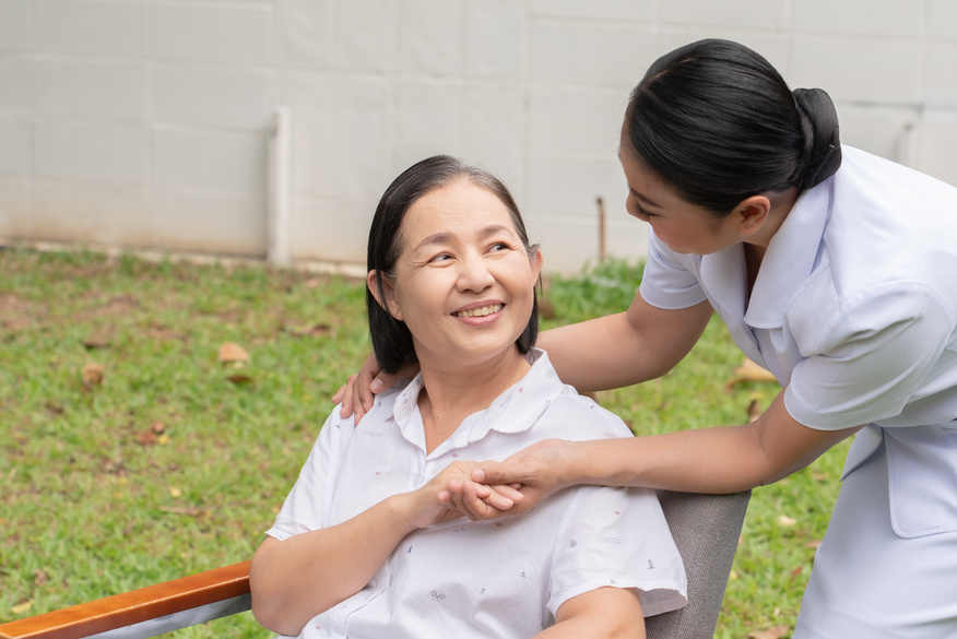 Female Caretaker with Senior Woman in the Yard